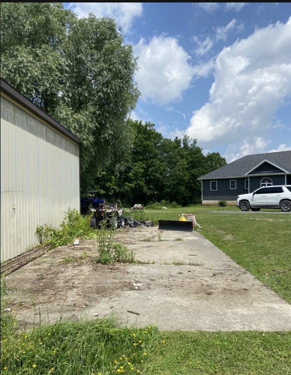 Same side yard after cleanout, cleared down to concrete pad